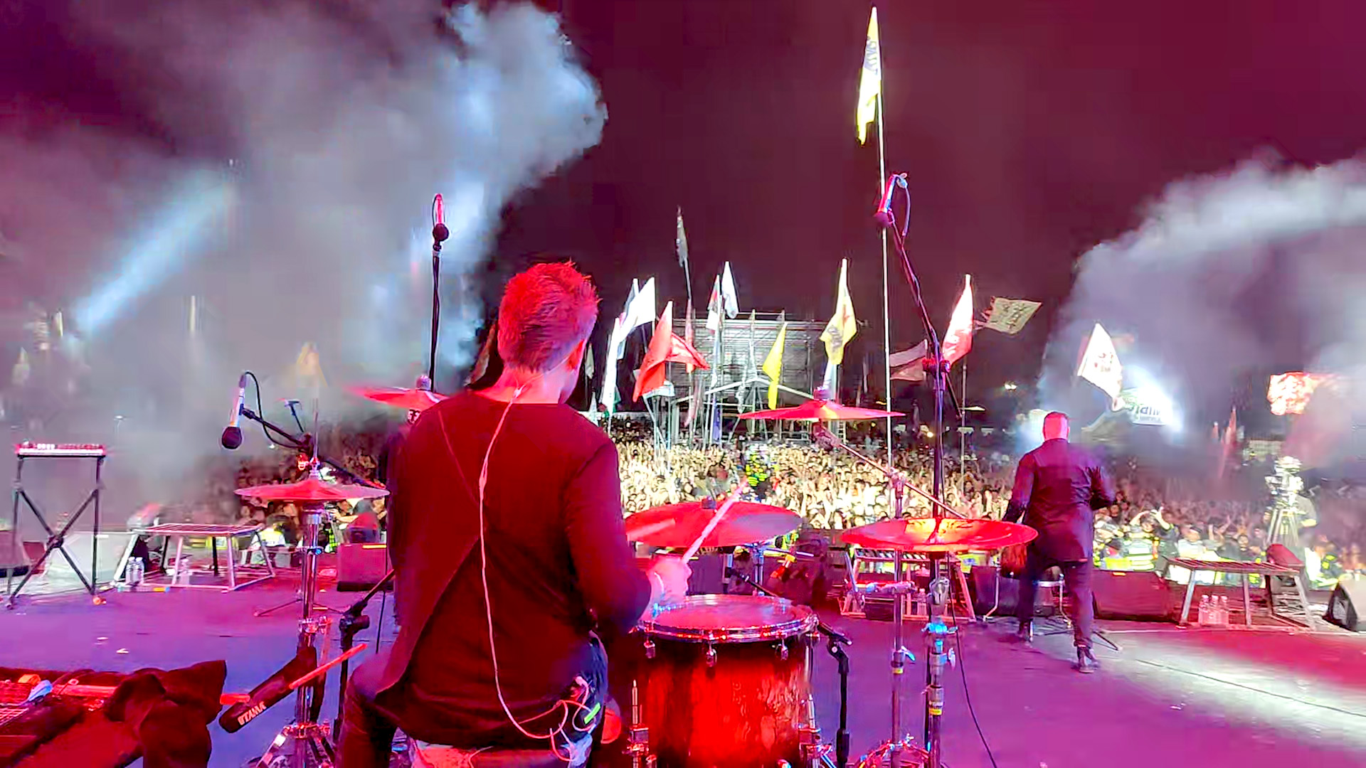 Dominic at the drums facing a large festival crowd