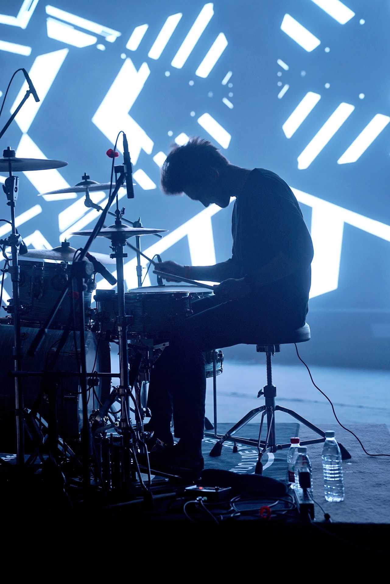 Silhouette of Dominic behind the drum kit